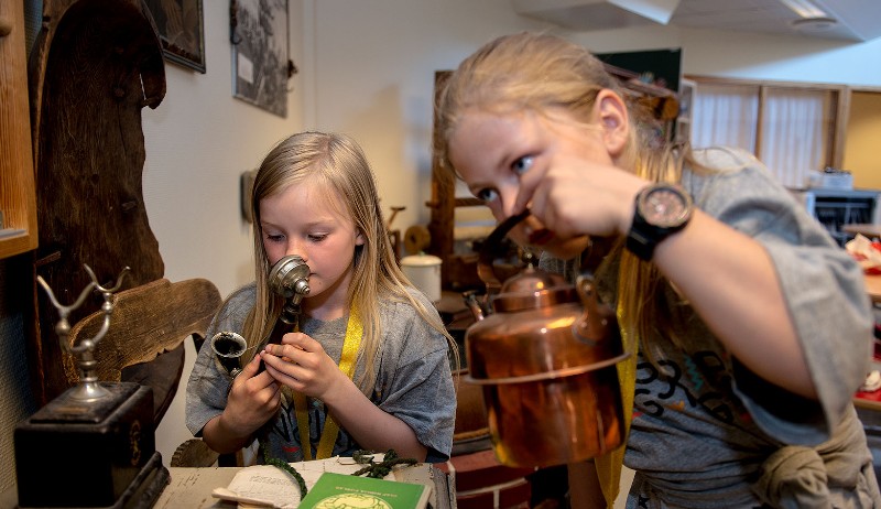 To barn som lukter på gamle gjenstander.