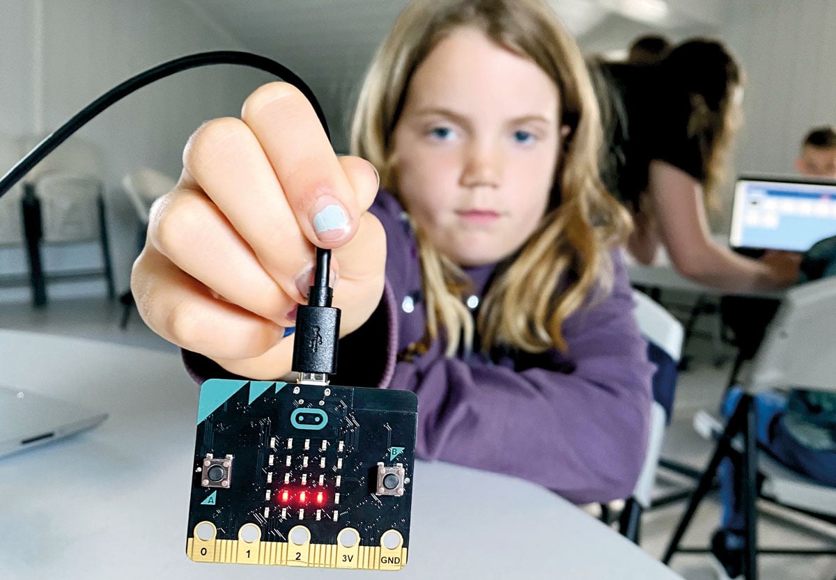 Jente holder opp Micro:bit