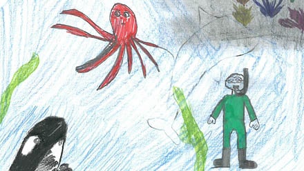 Gutt i grønn drakt som dykker under havet