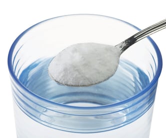 Skje med salt over vannglass