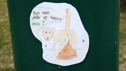 Plakat om å plukke opp hundebæsj festet til på søppelbøtte