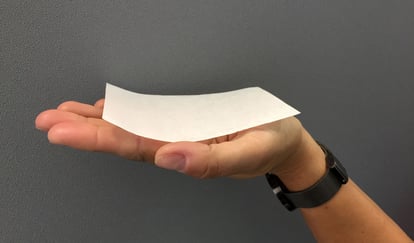 Hånd som holder et mellomleggspapir i håndflaten