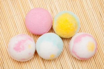 Fem fargerike badebomber som ligger på et bord. 