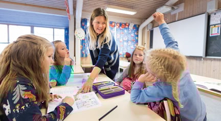 Elever og lærer som sitter i et klasserom