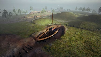Et vikingskip i et stort hull som er gravd ut i bakken