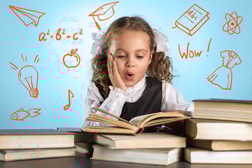 En jente sitter og leser i en bok