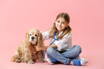 Jente leker doktor med en hund som pasient