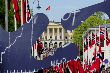 Bilde av et barnetog som går oppover en gate mot et slott 