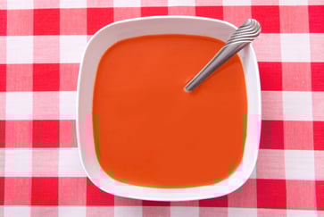 Bolle med tomatsuppe på rødrutete duk