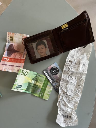 Bilde av en lommebok med penger, et fotografi, et heiskort og en kvittering