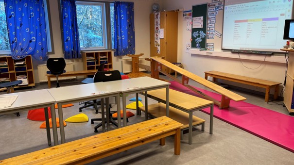 et klasserom der de leker gulvet er lava, benker og pulter står oppstilt etter hverandre