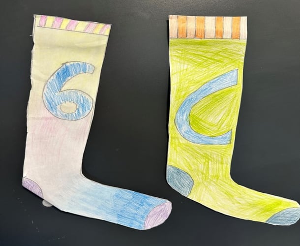 to fargerike sokker er tegnet, klippet ut og ligger på en svart overflate