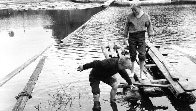 Bildet viser to gutter som leker ved Akerselva i 1962.