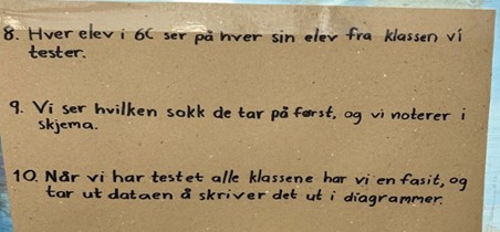 Plakat som ramser opp alle leddene som skal til for undersøkelsen del 2: 8. Hver elev i 6C ser på hver sin elev fra klassen vi tester. 9. Vi ser hvilken sokk de tar på først, og vi noterer i skjema.