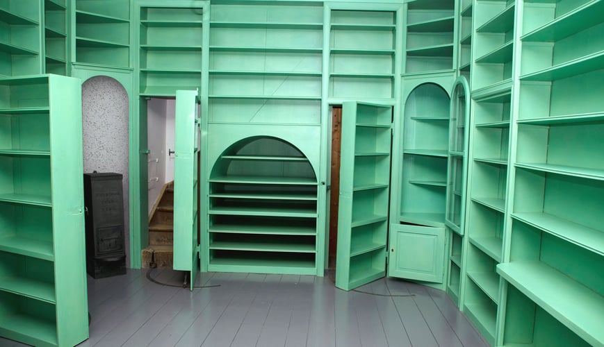 Et rom med grønne bokhyller på alle vegger