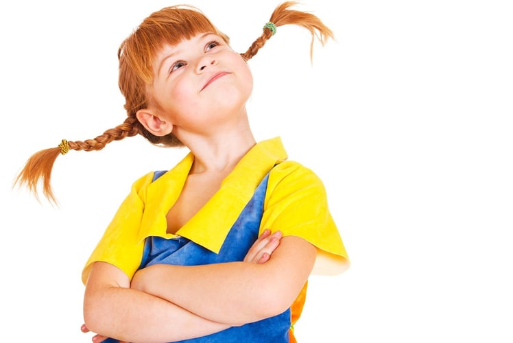 Pippi med røde fletter som står rett ut til siden. 