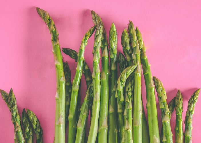 Grønne asparges mot rosa bakgrunn