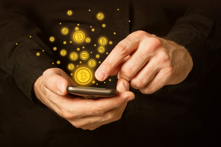 Bitcoins som spruter ut av en mobiltelefon