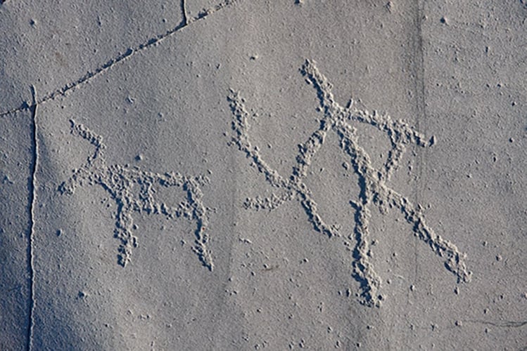 Helleristning av en mann som jakter på et reinsdyr.