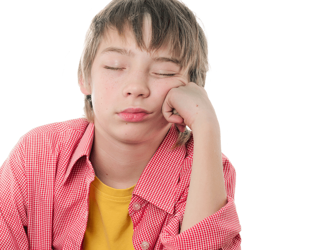 En gutt sitter og sover mens han lener hodet mot hånden.