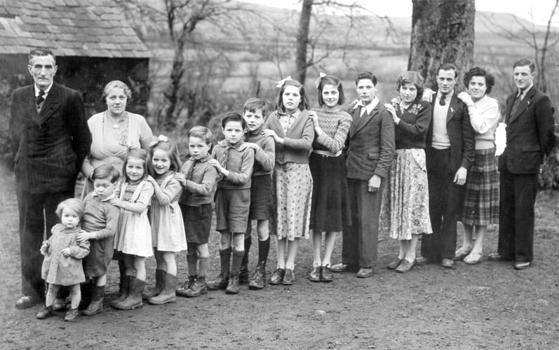 Sort-hvitt bilde av familien Brownie med mor og far og 14 barn i alderen 1 år til 24 år. 