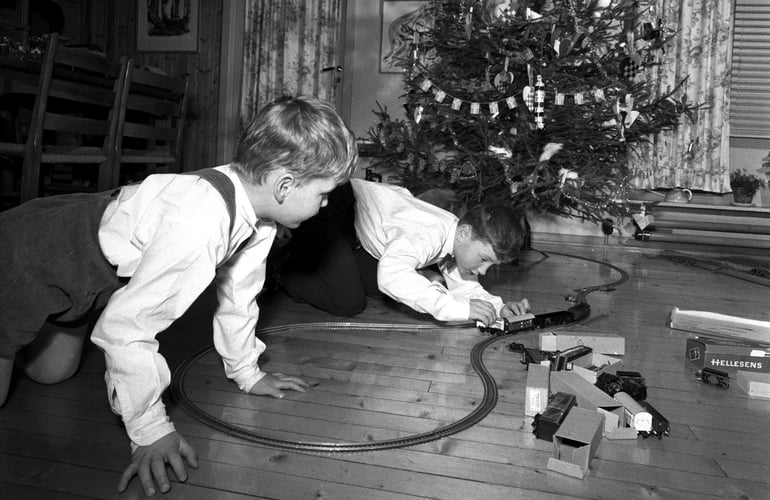 To gutter leker med en togbane de har fått i julegave (årstall 1957).