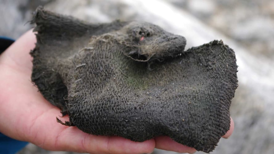 Et vått og brunt stykke tøy som ser vevd eller strikket ut