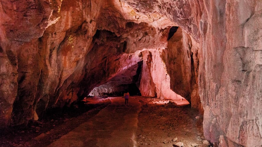 Menneske som går inn i grotte