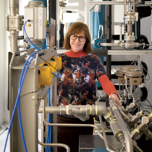 Kvinnelig forsker på laboraorium med mange maskiner rundt seg