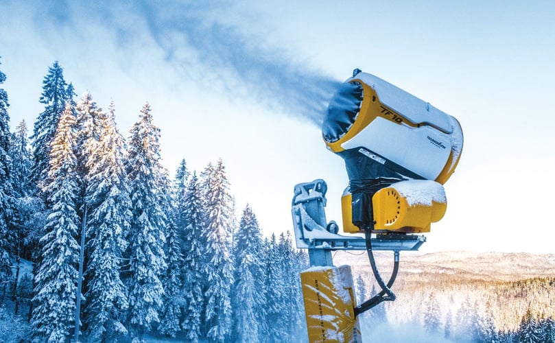 Gul snøkanon blåser snø ut i lufta