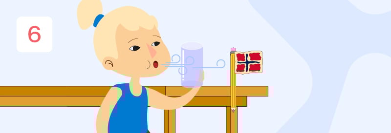 En jente med lyst hår i en hestehale som blåser på et glass