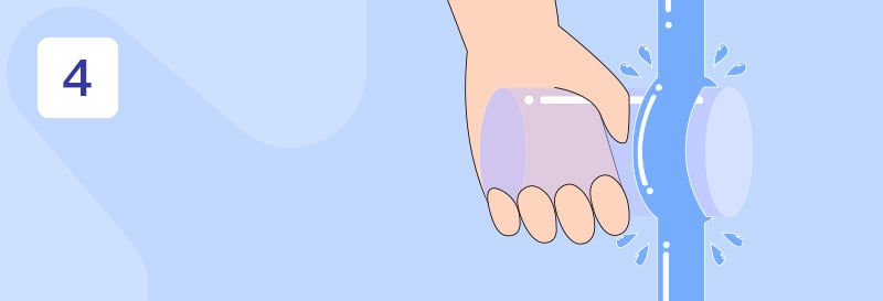 En hånd som holder et glass under rennende vann 