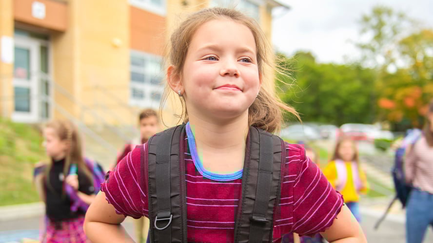 Fornøyd jente med ryggsekk på