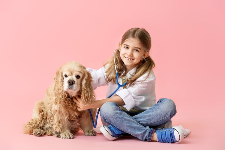 Jente leker doktor med en hund som pasient