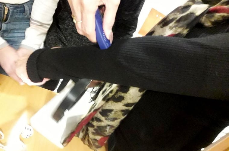 Et apparat som forteller hvilke farge klær har, holdes mot et erme