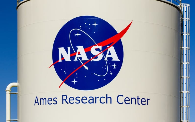 NASA ikonet med hvitebokstaver på en blå sirkel.på en stor syllinder