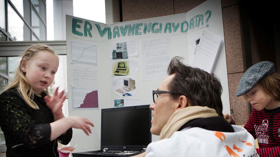Jente forklarer forskningsplakat for dommer