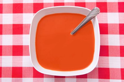 Bolle med tomatsuppe på rødrutete duk