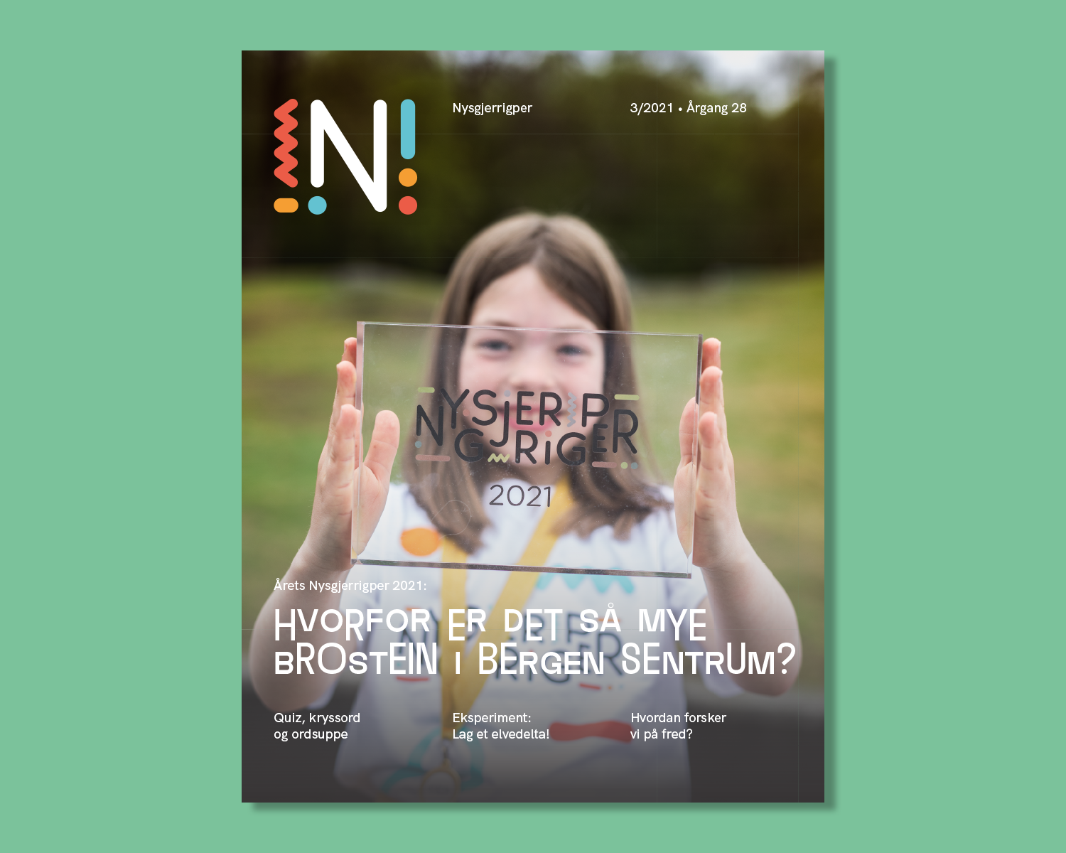 Forsiden på Nysgjerrigperblad med bilde av en jente som holder opp en blank plastplakett som sier Nysgjerrigper 2021